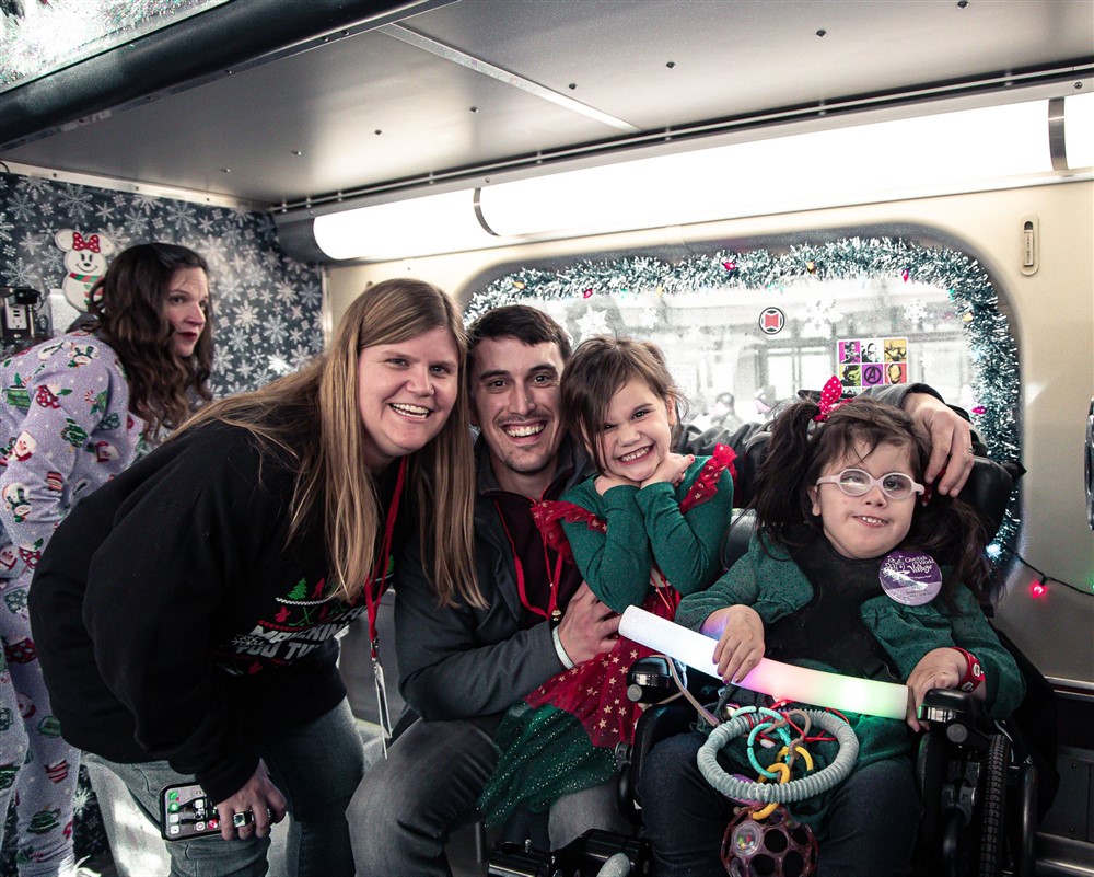 A smiling family together on the Operation North Pole train